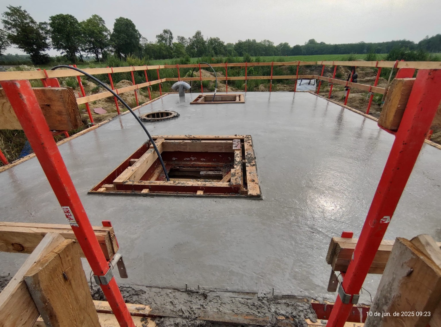 Dalle de béton fraîchement coulée avec réservations et garde-corps de chantier