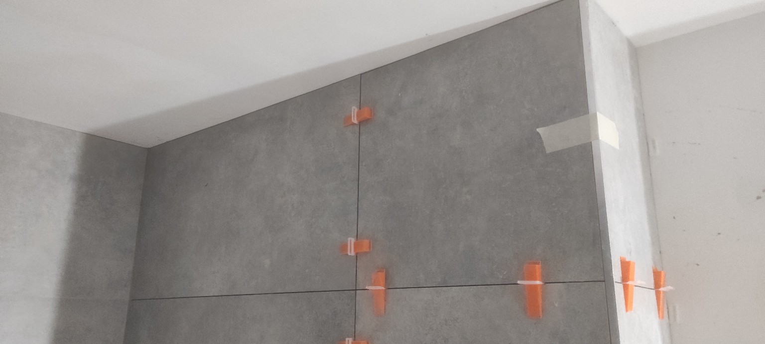 Pose et alignement de carreaux grand format sur les parois d’une pièce intérieure